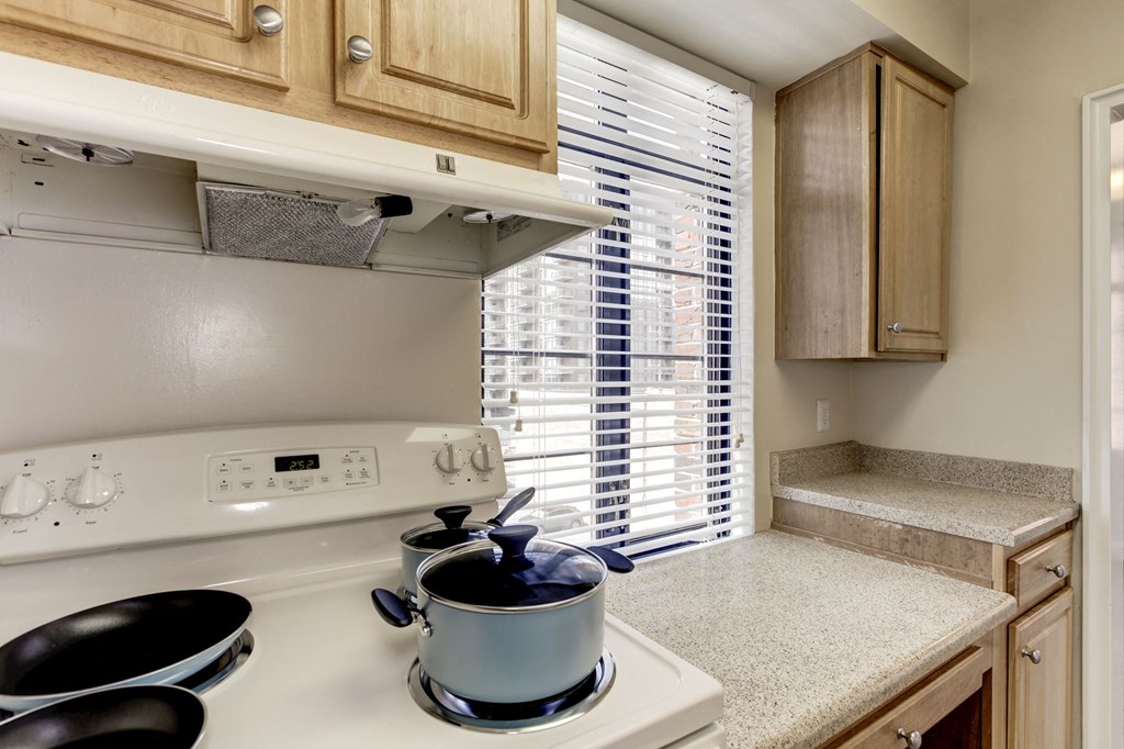 A kitchen with a stove top and a pot on it.