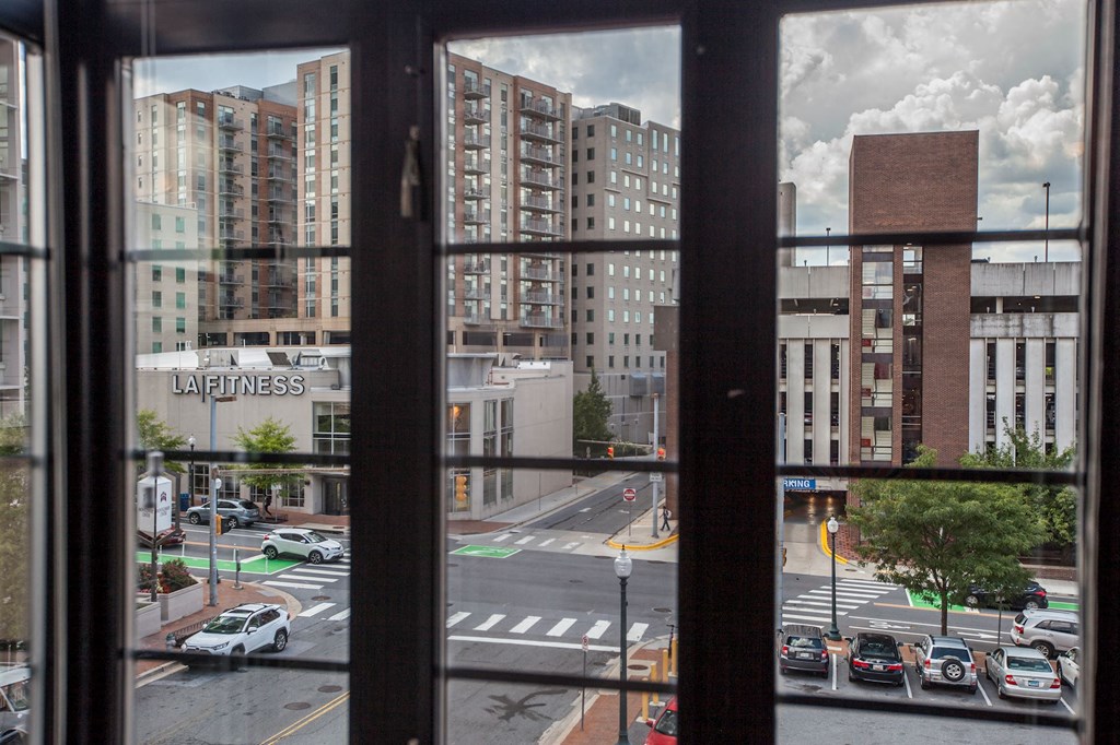 A view of a city street through a window with the word "LA Fitness" visible on a building.