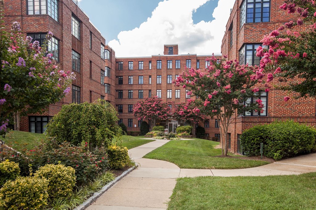 A red brick building with a green lawn in front.
