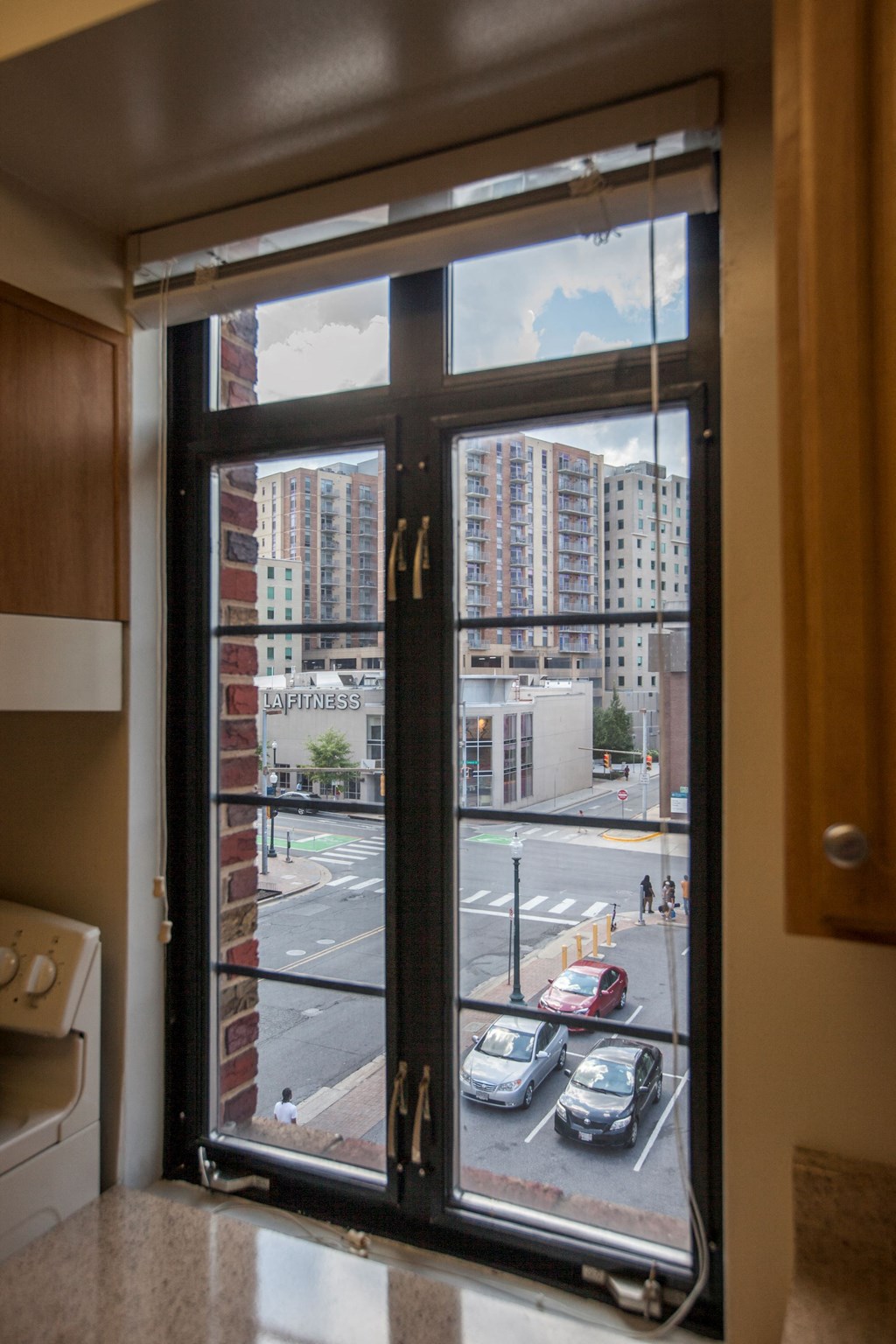 A view of a street through a window with a black frame.