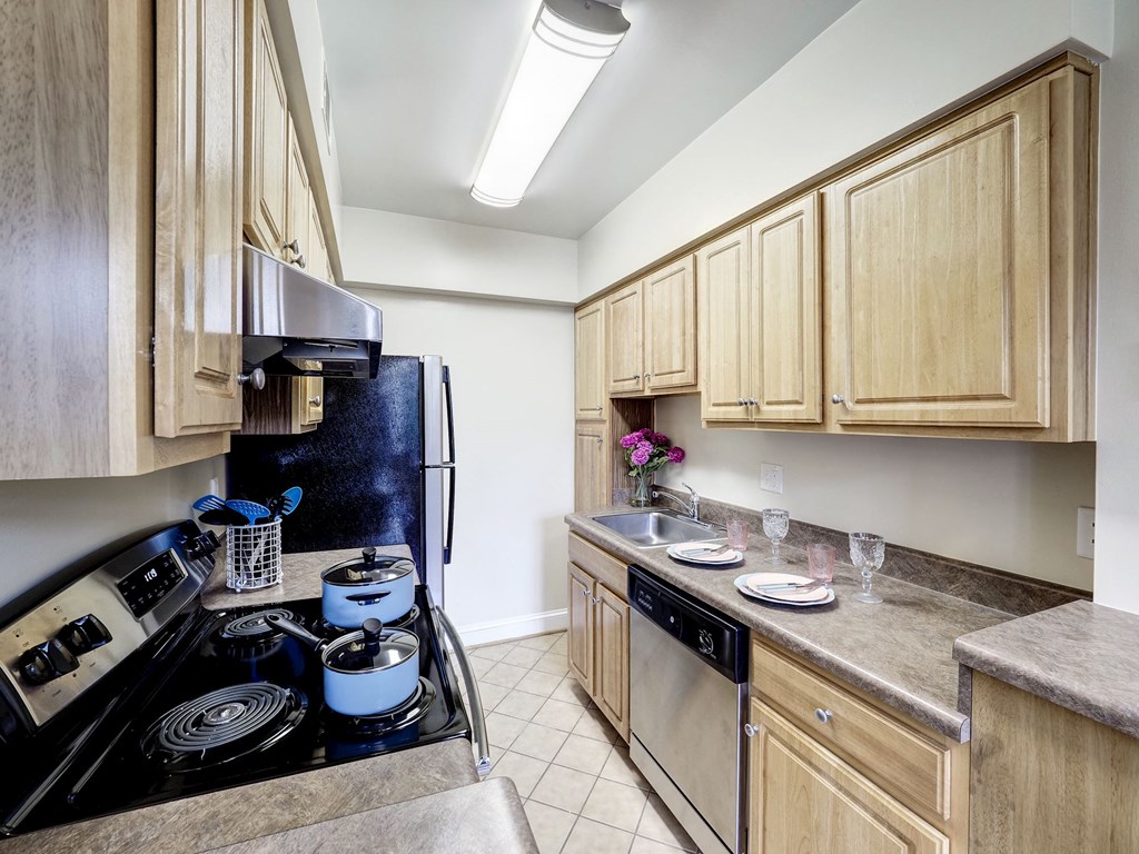 A kitchen with wooden cabinets and a black stove top.