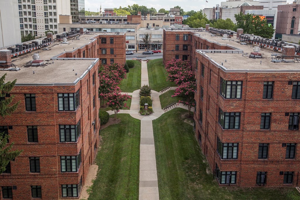 A view of a courtyard surrounded by red brick buildings.