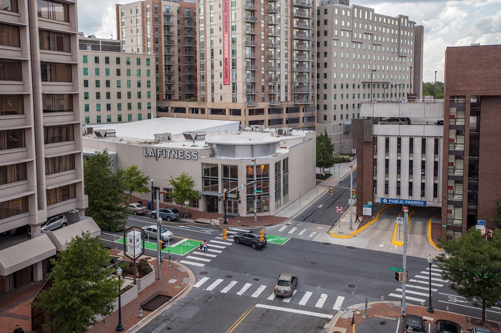 A view of a street with a La Fitness building in the background.