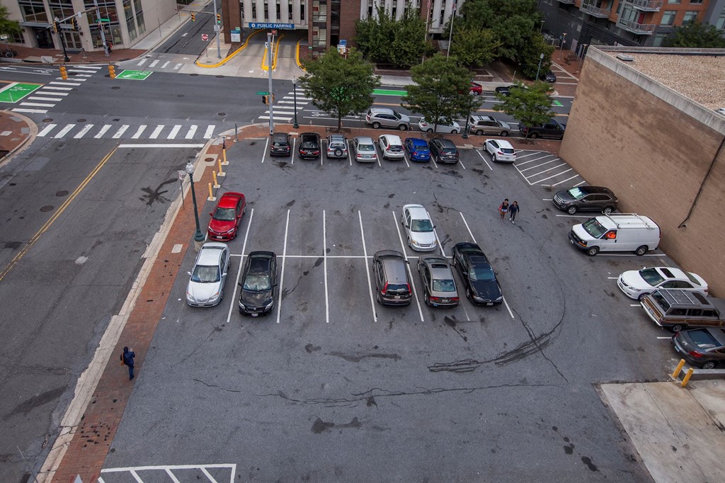 A parking lot with cars and a person walking.