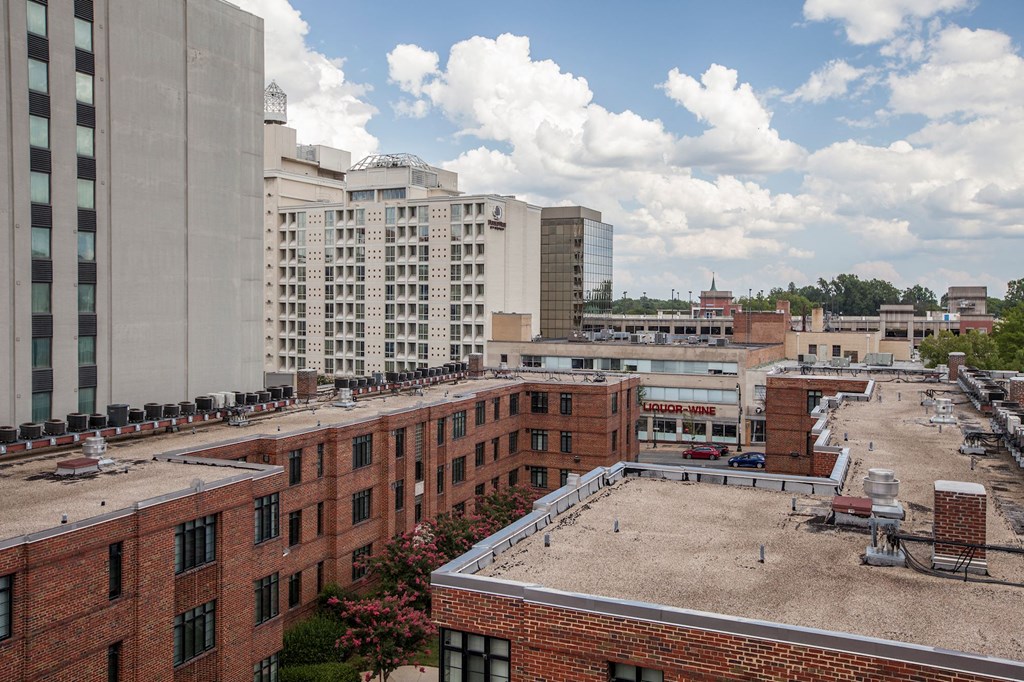 A cityscape with buildings and a parking lot.