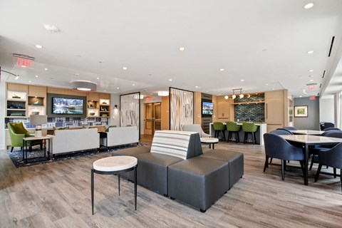 A modern lounge area with a variety of seating options and a bar area.