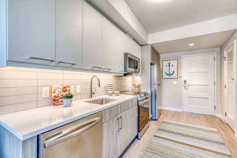 a large kitchen with stainless steel appliances and white cabinets