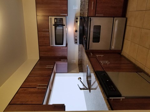 A kitchen with wooden cabinets and a white counter top.