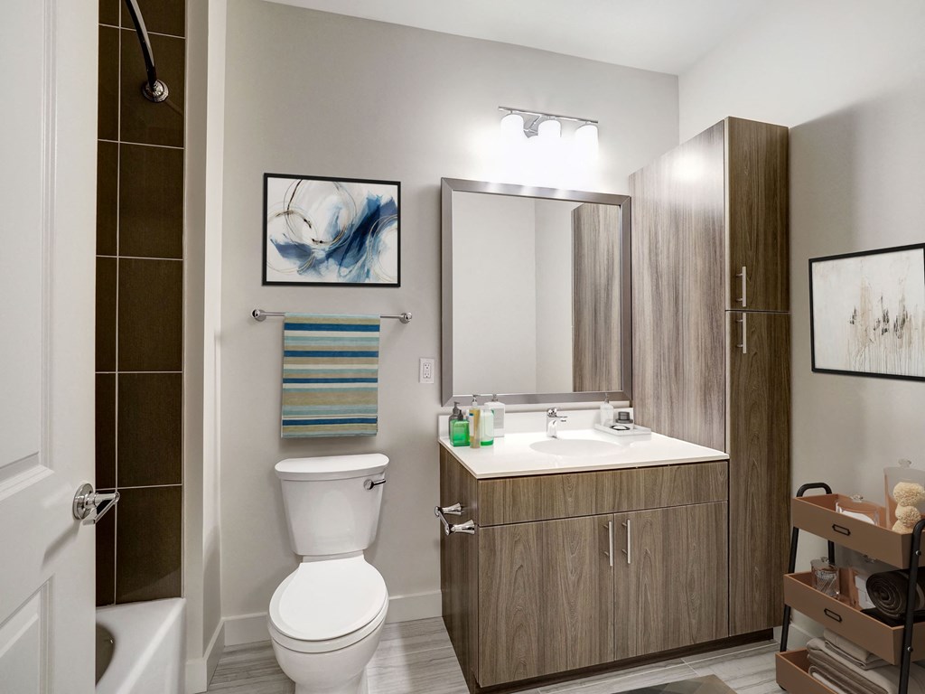 A bathroom with a toilet, sink, and mirror.