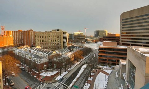A city street with buildings and cars on a winter day.