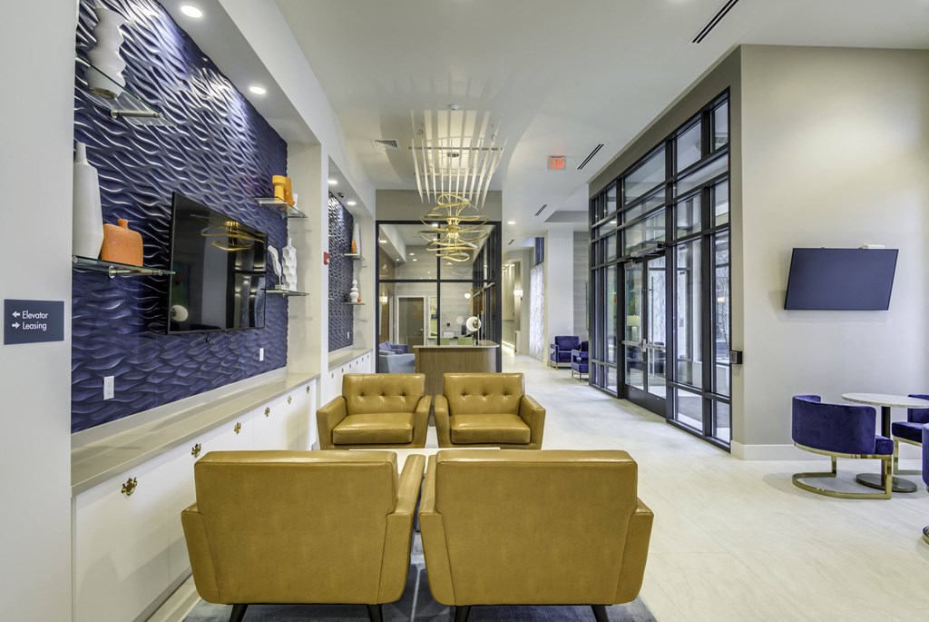 A long hallway with yellow chairs and a blue wall.