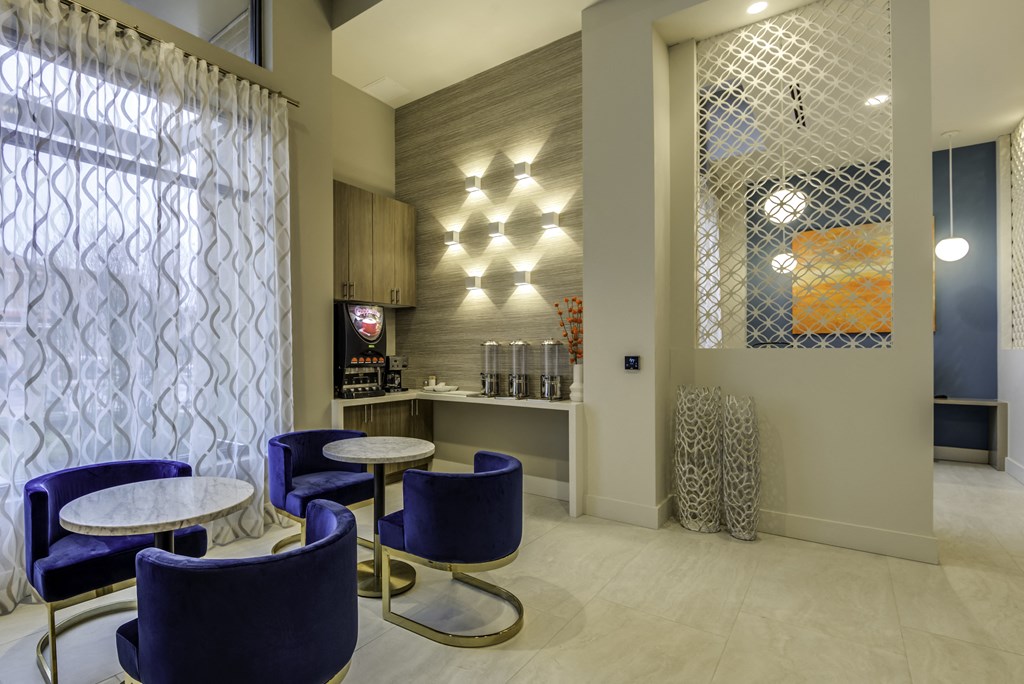 A modern cafe with blue chairs and a white table.