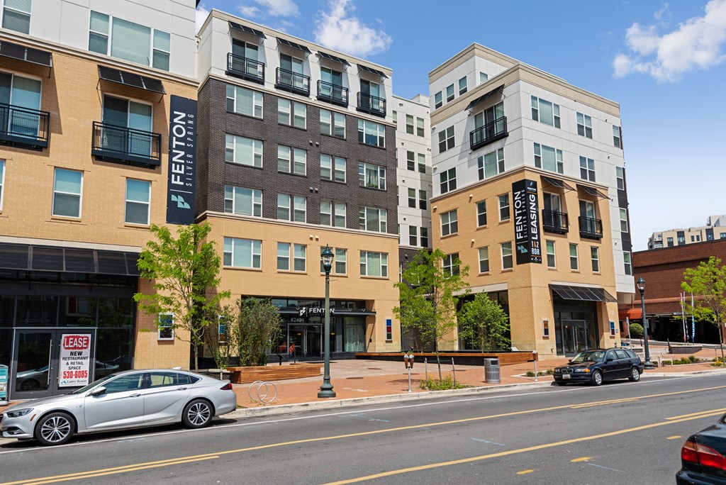 A street view of a residential area with cars and buildings.