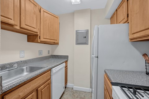A kitchen with wooden cabinets and a white refrigerator.