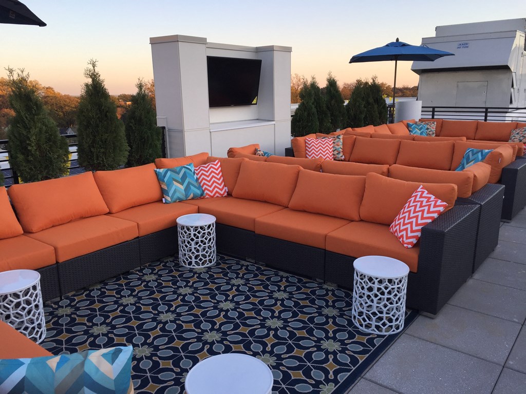 A patio with orange couches and a patterned floor.