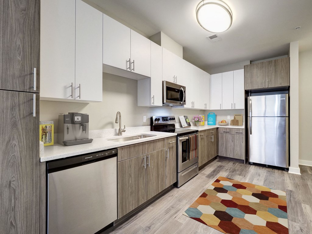 A modern kitchen with a white countertop and stainless steel appliances.