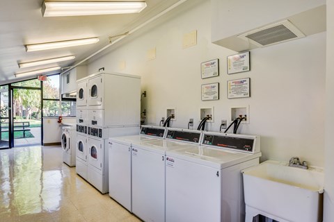 A laundromat with a row of washers and dryers.