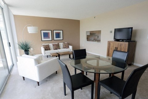 A living room with a glass table and white couch.