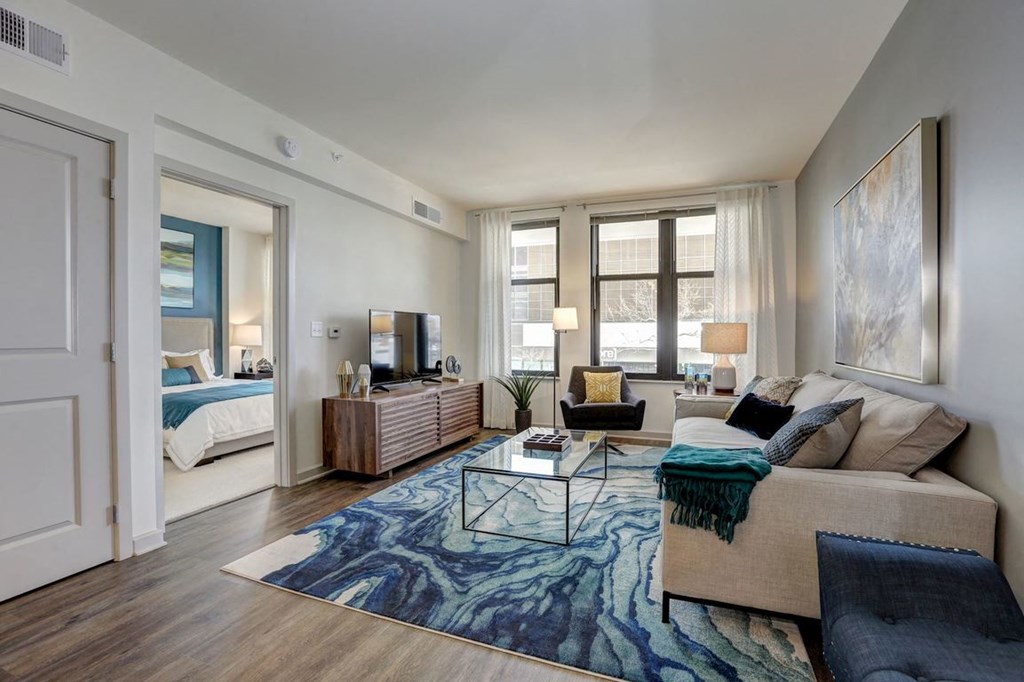 A living room with a couch, a coffee table, and a large painting on the wall.