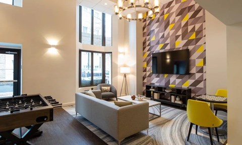 A modern living room with a yellow chair and a grey sofa.