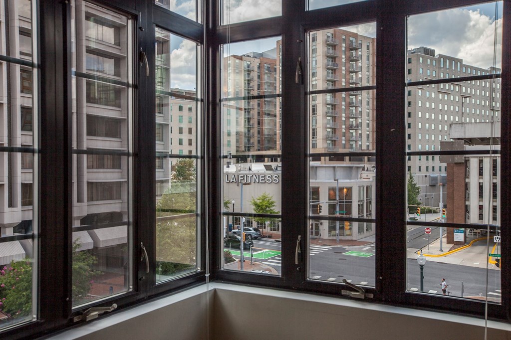 A view from inside a room looking out onto a street with the word "LA PLAZA" visible on a sign.