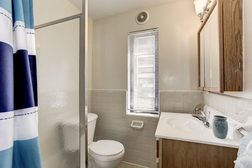A bathroom with a toilet, sink, and shower curtain.