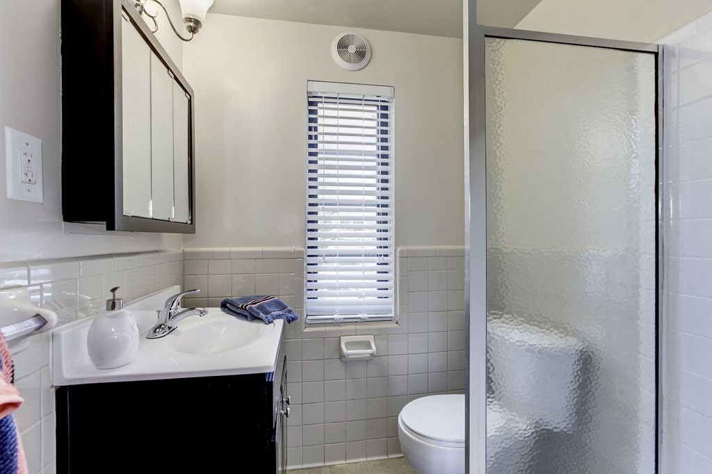 A bathroom with a sink, toilet, and shower.