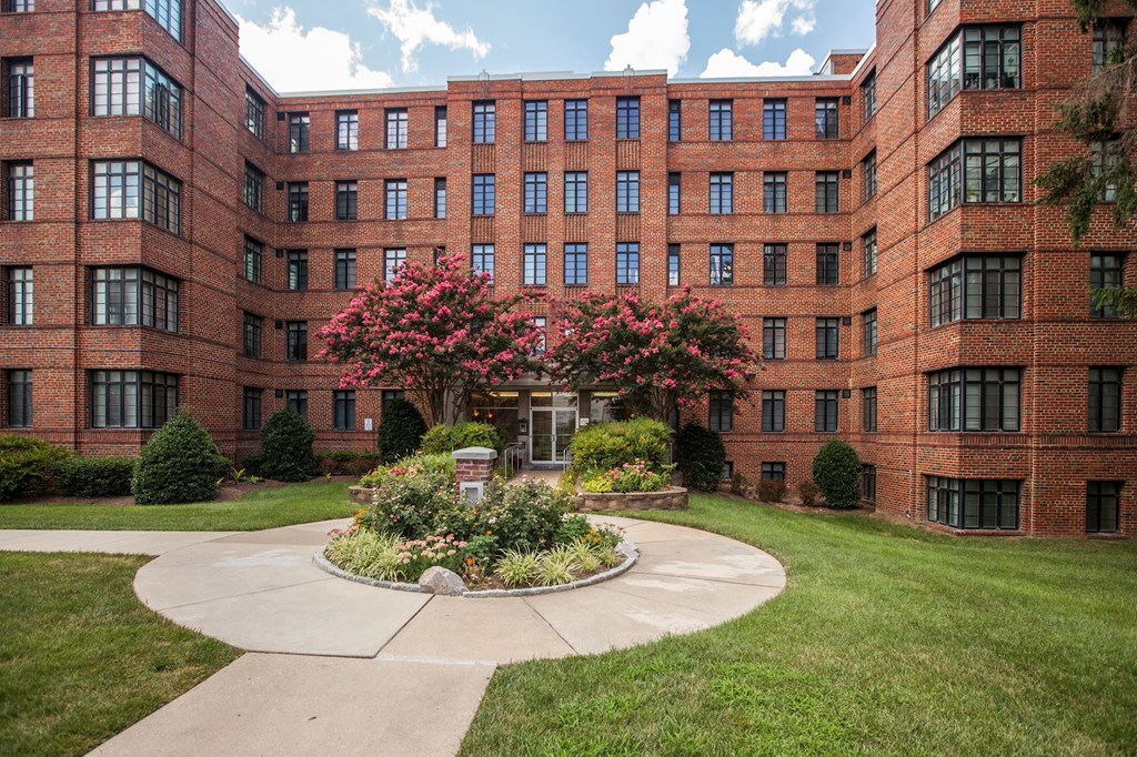 A courtyard with a fountain surrounded by red brick buildings.
