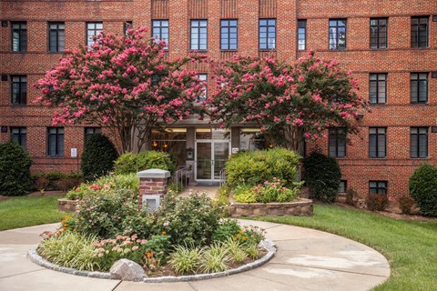 A red brick building with a tree in front of it.