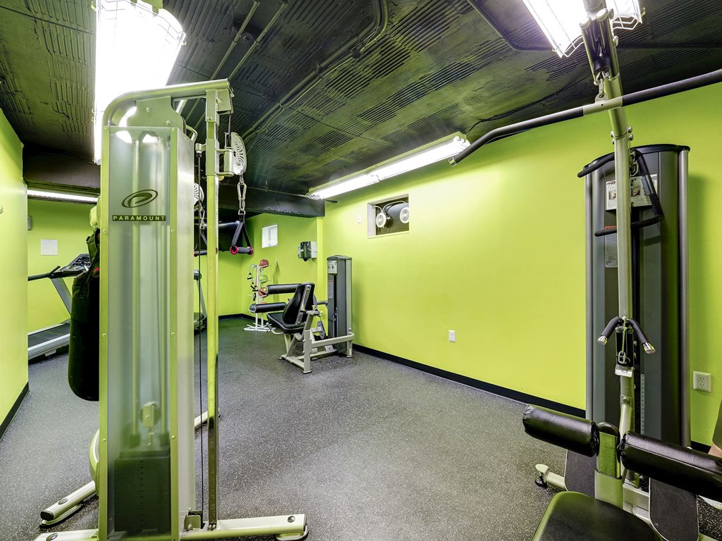 A gym with a green wall and a weight machine.