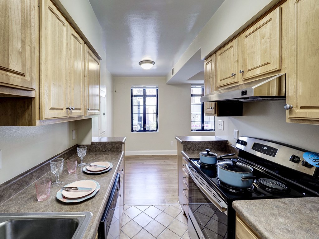 A kitchen with wooden cabinets and a black stove top oven.