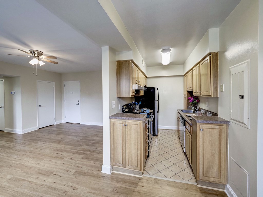 A kitchen with wooden cabinets and a black refrigerator.
