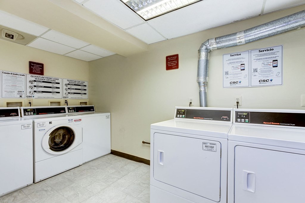 A laundry room with washers and dryers and a sign that says "Servicio".