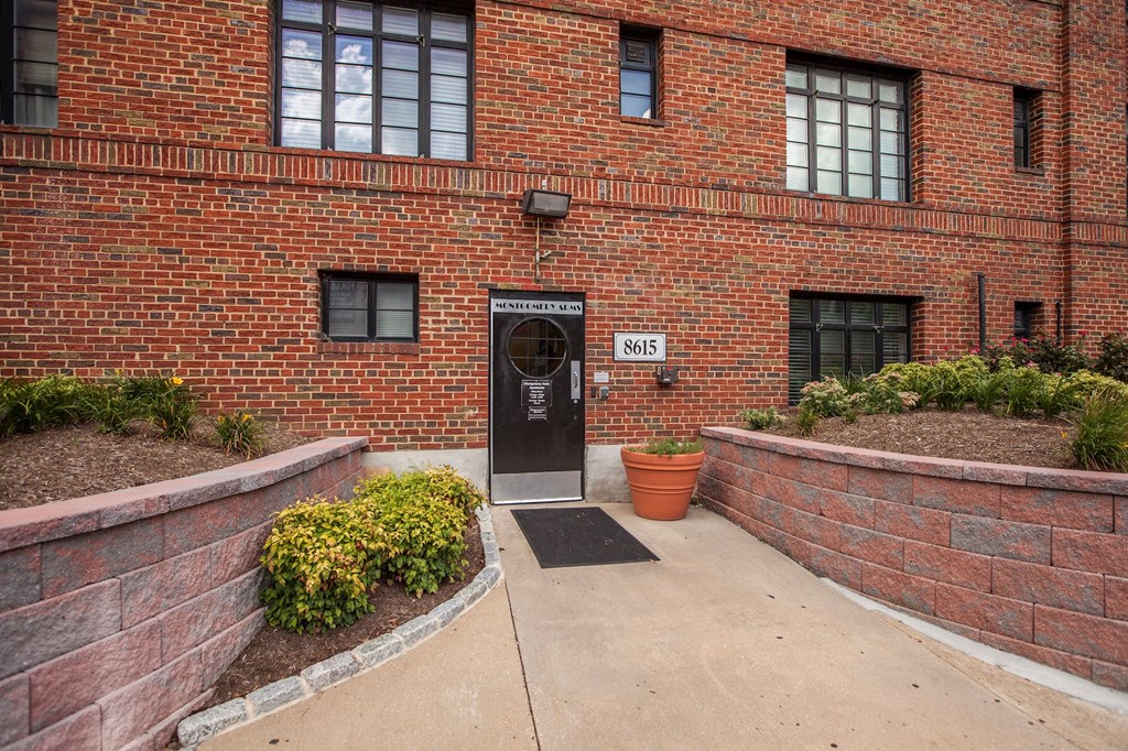 A brick building with a black door and windows.