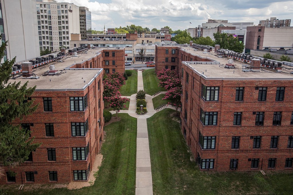 A view of a courtyard surrounded by red brick buildings.