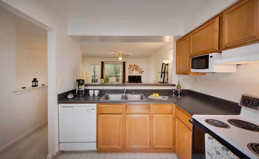 A kitchen with wooden cabinets and black countertops.