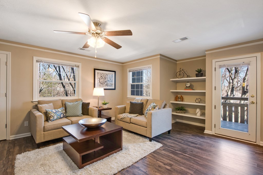 A living room with a couch, a coffee table, and a ceiling fan.