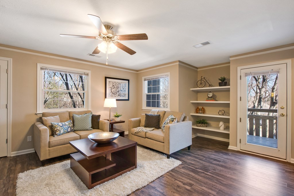 A living room with a couch, a coffee table, and a ceiling fan.