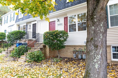 A house with a red door and a tree in front.