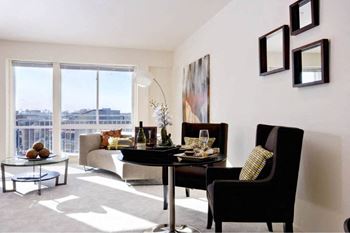 A living room with a table and chairs and a view of the city.