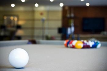 A white ball is on a pool table.