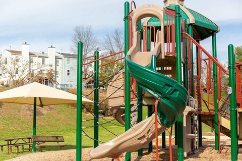 A playground with a green and red slide.