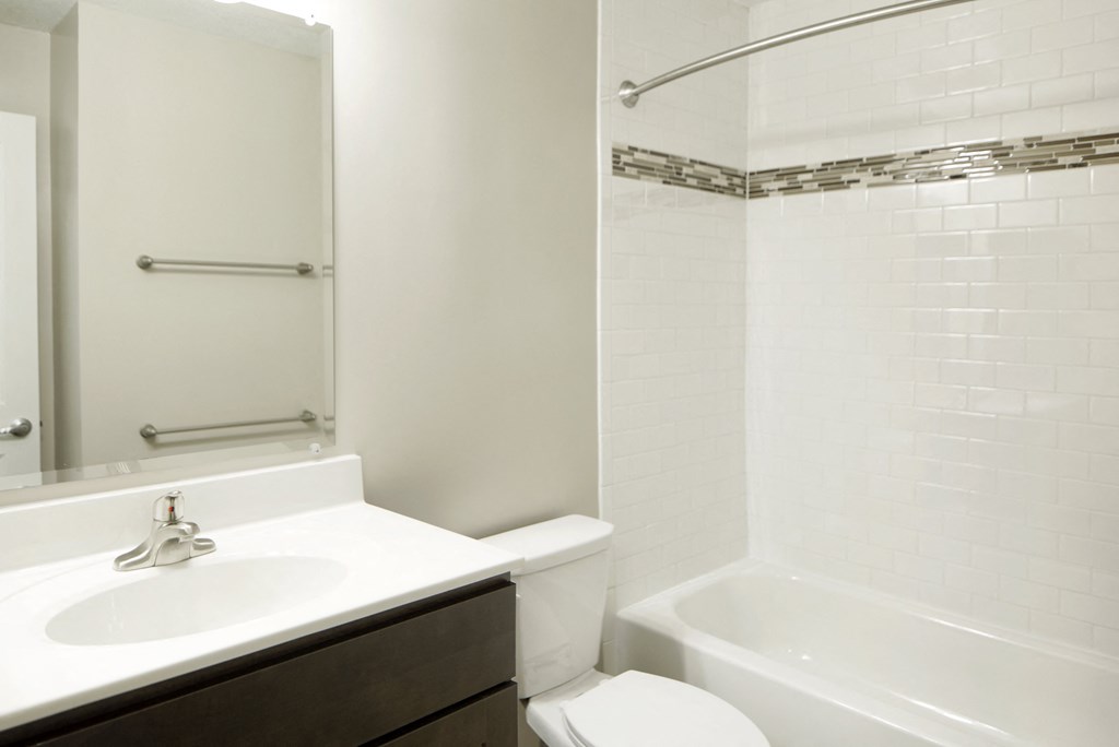 A white bathroom with a sink, toilet and bathtub.