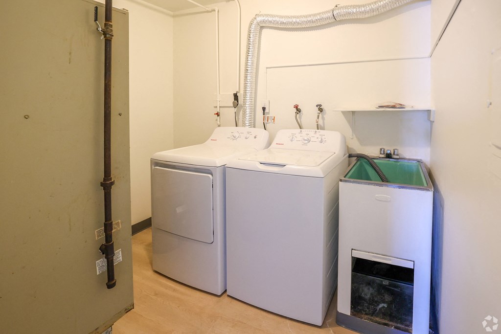 A room with a washing machine and a dryer.