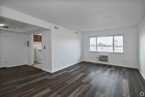 A room with a large window and a wooden floor.