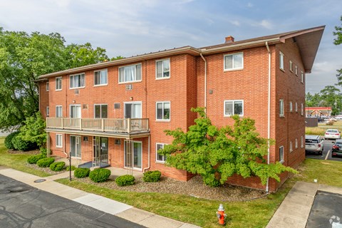 A red brick apartment building with a fire hydrant in front.