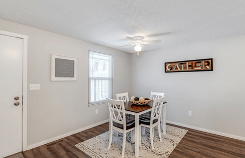 A dining room with a white table and chairs.
