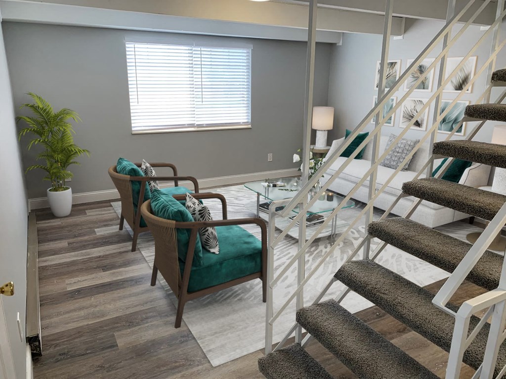 a living room with chairs and a staircase