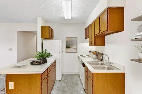 A kitchen with wooden cabinets and a white refrigerator.