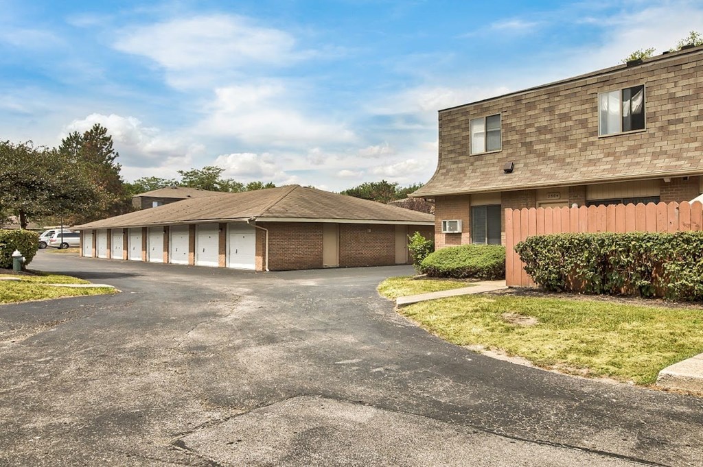 a parking lot in front of a house with a car garage